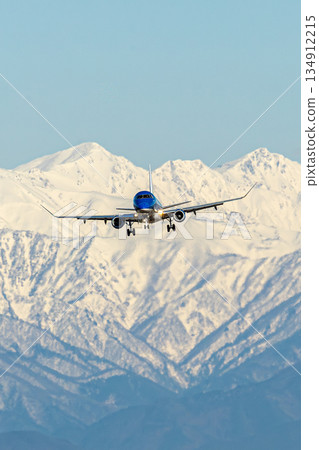 An airplane flying with the Northern Alps in the background An airplane flying with the Northern Alps in the background 134912215
