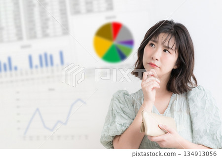 A woman considering investing in NISA and iDeCo, with an investment graph showing household finances and asset management in the background 134913056