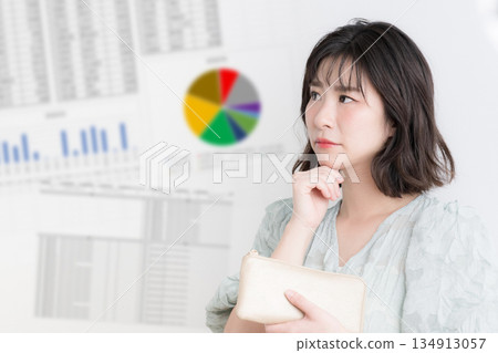 A woman considering investing in NISA and iDeCo, with an investment graph showing household finances and asset management in the background A woman considering investing in NISA and iDeCo, with an investment graph showing household finances and asset management in the background 134913057