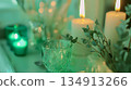 A green table with candles and a green glass 134913266