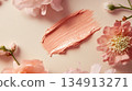 A pink brush stroke of makeup is on a white background with pink flowers 134913271