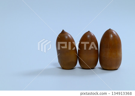 藍色背景上排列著三顆橡子 134913368