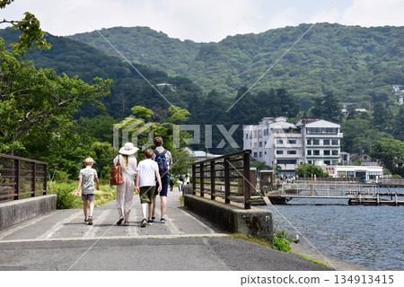 A foreign family strolling along the shores of Lake Ashi near Motohakone Port in Hakone Town A foreign family strolling along the shores of Lake Ashi near Motohakone Port in Hakone Town 134913415