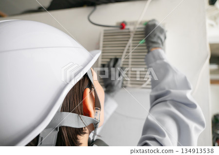 檢查空調設備的婦女 檢查空調設備的婦女 134913538
