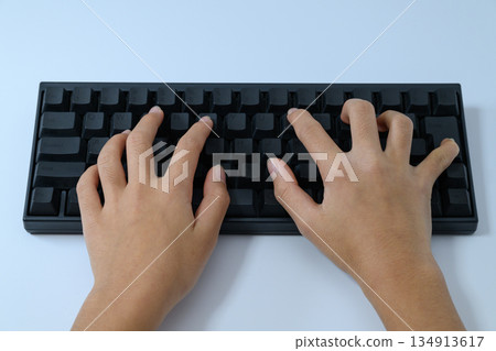 A child's hands typing on a keyboard seen from directly above A child's hands typing on a keyboard seen from directly above 134913617