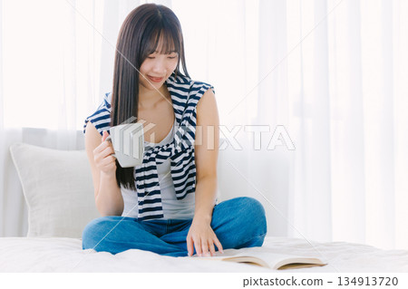 年輕女子在床上喝咖啡 134913720