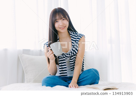 年輕女子在床上喝咖啡 134913903