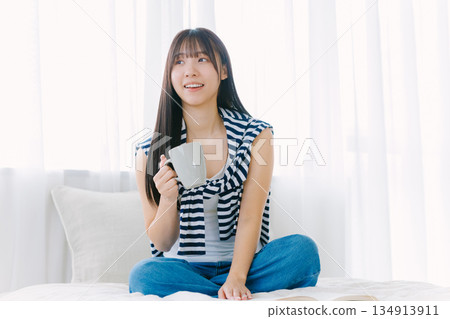 年輕女子在床上喝咖啡 134913911