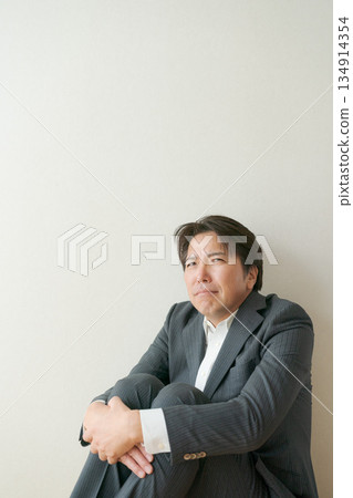 一名五十多歲、蹲著的辦公室職員 134914354