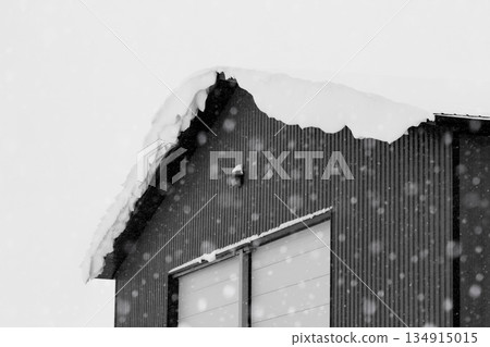 Industrial storage building covered with snow after snowfall. 134915015