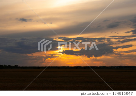 Dramatic orange sunset light in the sky over autumn prairies. 134915047