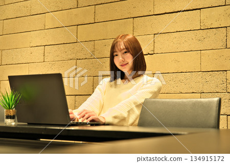 一位女商人正在辦公室使用筆記型電腦工作。 一位女商人正在辦公室使用筆記型電腦工作。 134915172