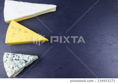 Set of various types of cheese on black slate background. Top view 134915271