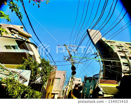 A snapshot of a Japanese residential area with blue skies and power lines intersecting A snapshot of a Japanese residential area with blue skies and power lines intersecting 134915410