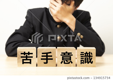 A male student is troubled by a block that says "weakness" A male student is troubled by a block that says "weakness" 134915734