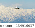 An airplane flying with the Northern Alps in the background 134916037