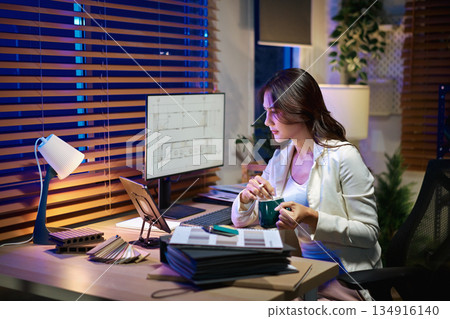 Architect interior designer working on digital tablet, choosing materials and colors from samples 134916140