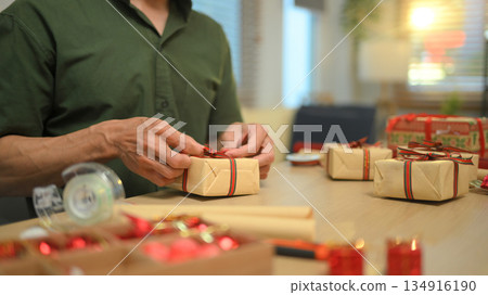 Photo set Man wrapping Christmas gifts at home with scissors and festive decorations 134916190