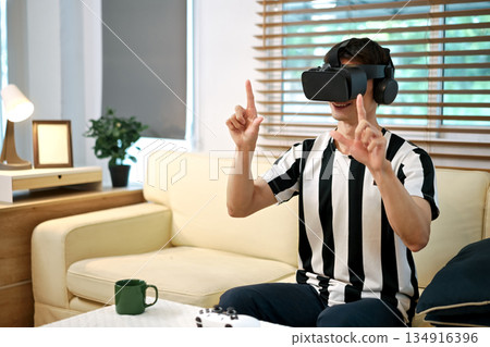 Excite white man playing online game with vr glasses at home 134916396