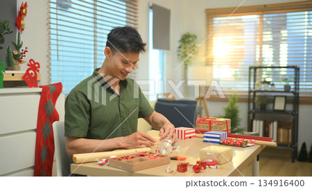 Photo set Man wrapping Christmas gifts at home with scissors and festive decorations Photo set Man wrapping Christmas gifts at home with scissors and festive decorations 134916400