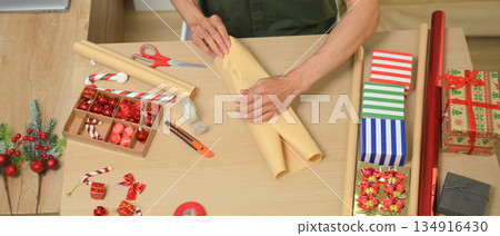 Photo set Man wrapping Christmas gifts at home with scissors and festive decorations Photo set Man wrapping Christmas gifts at home with scissors and festive decorations 134916430