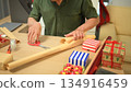 Photo set Man wrapping Christmas gifts at home with scissors and festive decorations 134916459