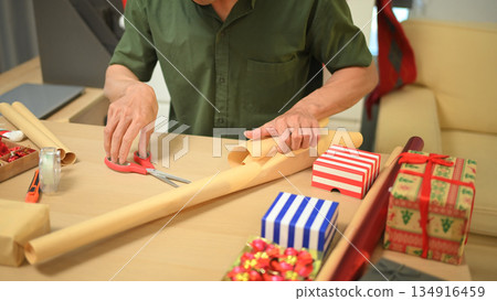 Photo set Man wrapping Christmas gifts at home with scissors and festive decorations Photo set Man wrapping Christmas gifts at home with scissors and festive decorations 134916459