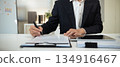 Closeup image businessman sitting at desk signing contract 134916467