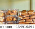 Fresh sweet pastries in a transparent container stand on the shelves of a grocery store 134916891
