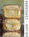 Fresh sweet pastries in a transparent container stand on the shelves of a grocery store 134916894