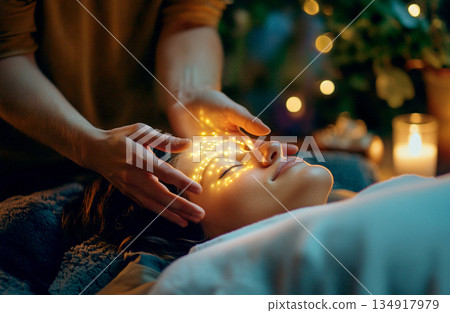 healing power of Reiki. A woman women is receiving a therapeutic massage. spiritual energy transfer reiki head heart massage. woman receiving reiki massage healing hand placement 134917979