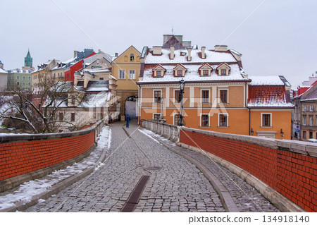 Buildings and pathways in a snowy cityscape during winter in Lublin Buildings and pathways in a snowy cityscape during winter in Lublin 134918140