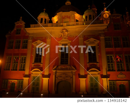 Historic building in a city square at night with lights and towers 134918142