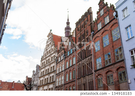 Historic buildings line the street under a cloudy sky in a European city Historic buildings line the street under a cloudy sky in a European city 134918183
