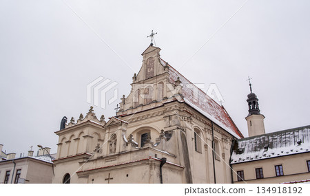 Snow covers the rooftop of a historical church in a small town during winter 134918192