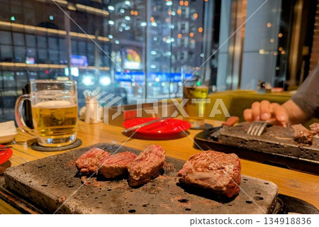 成人欣賞夜景，享用肉類菜餚 134918836