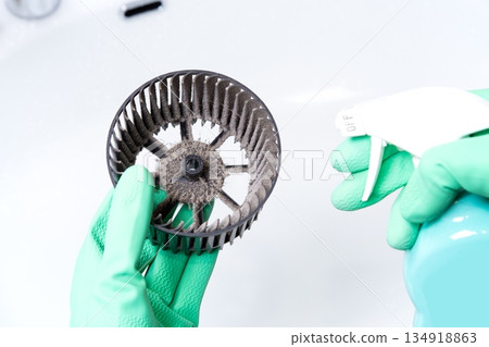 一個人正在用清潔劑清洗髒兮兮的通風扇的西洛克風扇。 134918863