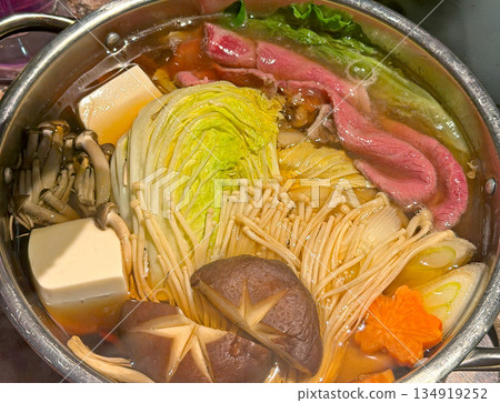 Delicious hot pot brimming with fresh ingredients and thinly sliced beef in a savory broth 134919252