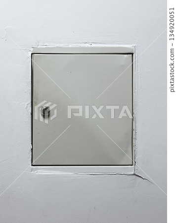 Square metal access panel on a white wall. Square metal access panel on a white wall. 134920051