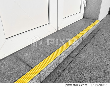 Yellow safety strip on building entrance step for accessibility. Yellow safety strip on building entrance step for accessibility. 134920086