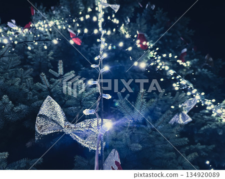 Christmas tree with lights and bows at night. 134920089