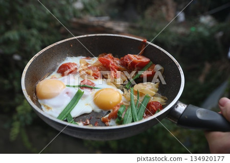 Fried eggs with spinach and pumpkin,shalots; tomatoes in a frying pan Fried eggs with spinach and pumpkin,shalots; tomatoes in a frying pan 134920177
