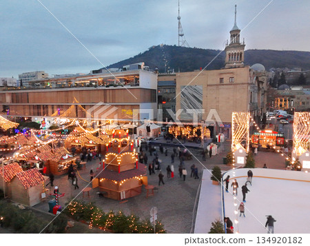 Christmas tree and market on Rose Revolution square at twilight - Christmas lights on tree and kiosks with food and mulled wine Christmas tree and market on Rose Revolution square at twilight - Christmas lights on tree and kiosks with food and mulled wine 134920182