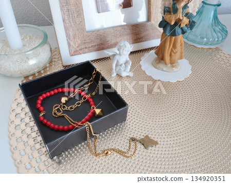 Christian corner at home. Icons and candles. Angel figurine and bracelet. Faith, symbols, and traditions. 134920351