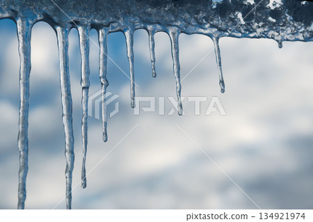 Winter icicles hanging against blue sky closeup 134921974
