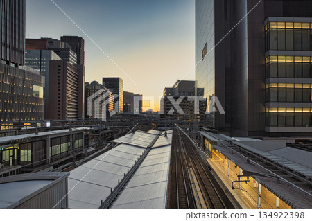 夕陽西下,大阪梅田的城市天際線染上了一層迷人的色彩,這座大都市現代建築與鐵路在此交會融合。 夕陽西下,大阪梅田的城市天際線染上了一層迷人的色彩,這座大都市現代建築與鐵路在此交會融合。 134922398
