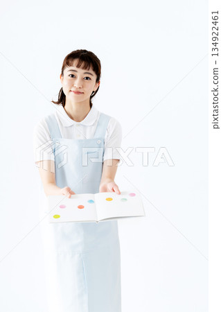 一位幼兒園老師拿著圖畫書 134922461