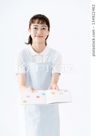 一位幼兒園老師拿著圖畫書 134922462