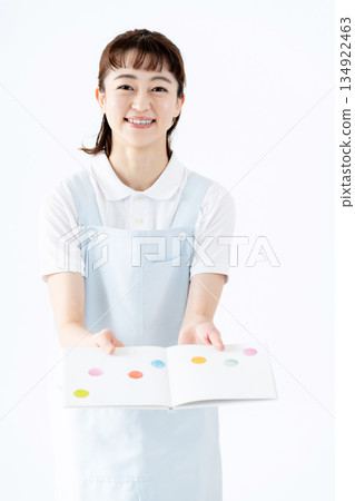 一位幼兒園老師拿著圖畫書 134922463