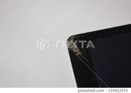 Shattered screen of a tablet computer, revealing the internal components and back cover 134922555
